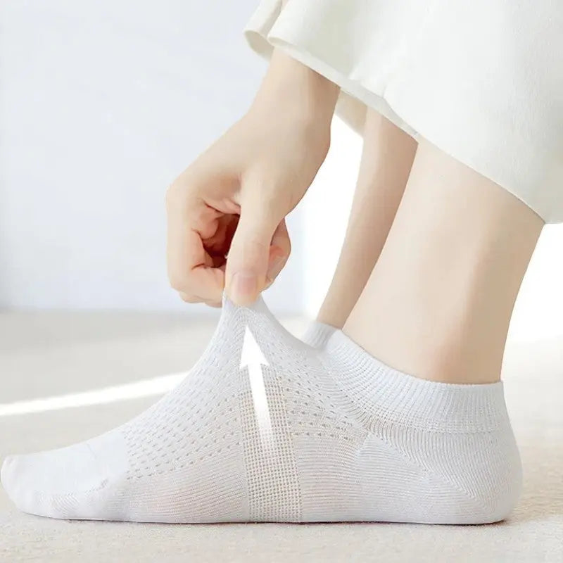 Chaussette blanche respirante pour femme, montrant sa souplesse et sa légèreté au niveau du cou-de-pied.