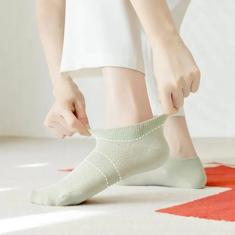 Chaussette anti transpiration vert pâle enfilée, illustrant son élasticité et sa coupe confortable.