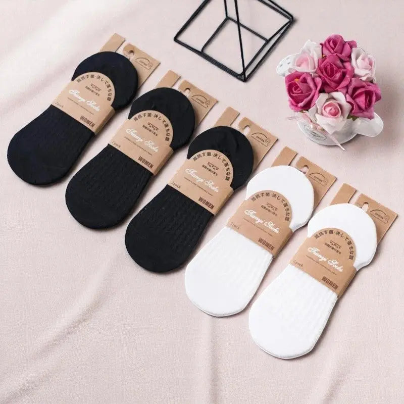 Chaussettes invisibles noires et blanches pour femme, présentées en lot avec emballage kraft raffiné.
