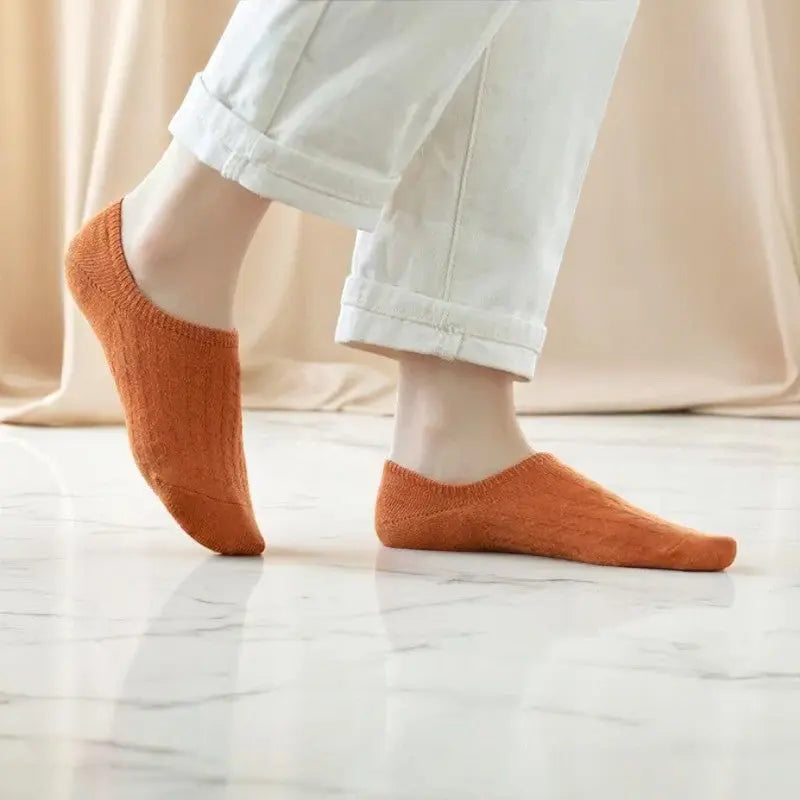 Chaussette invisible orange pour femme sur sol marbré, parfaite pour rester invisible tout en gardant le pied au chaud.