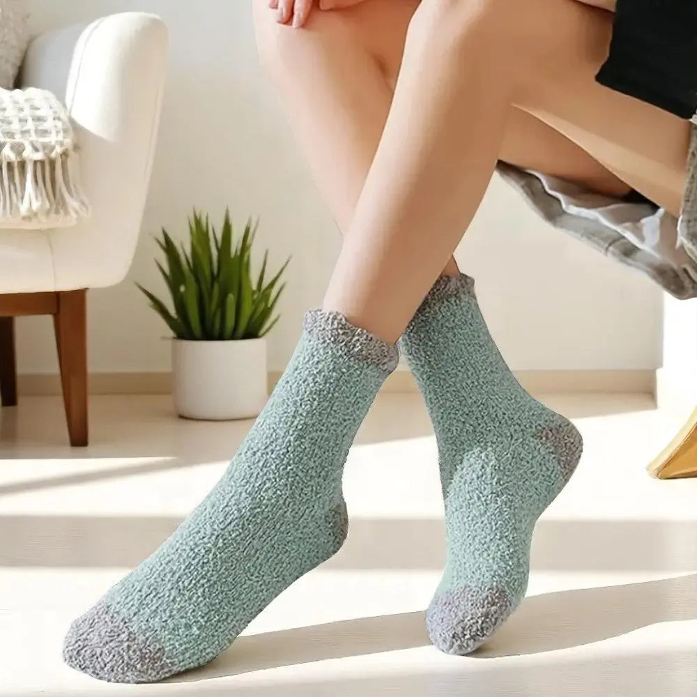 Chaussettes en laine pour femme bleu pastel et gris portées à la maison.