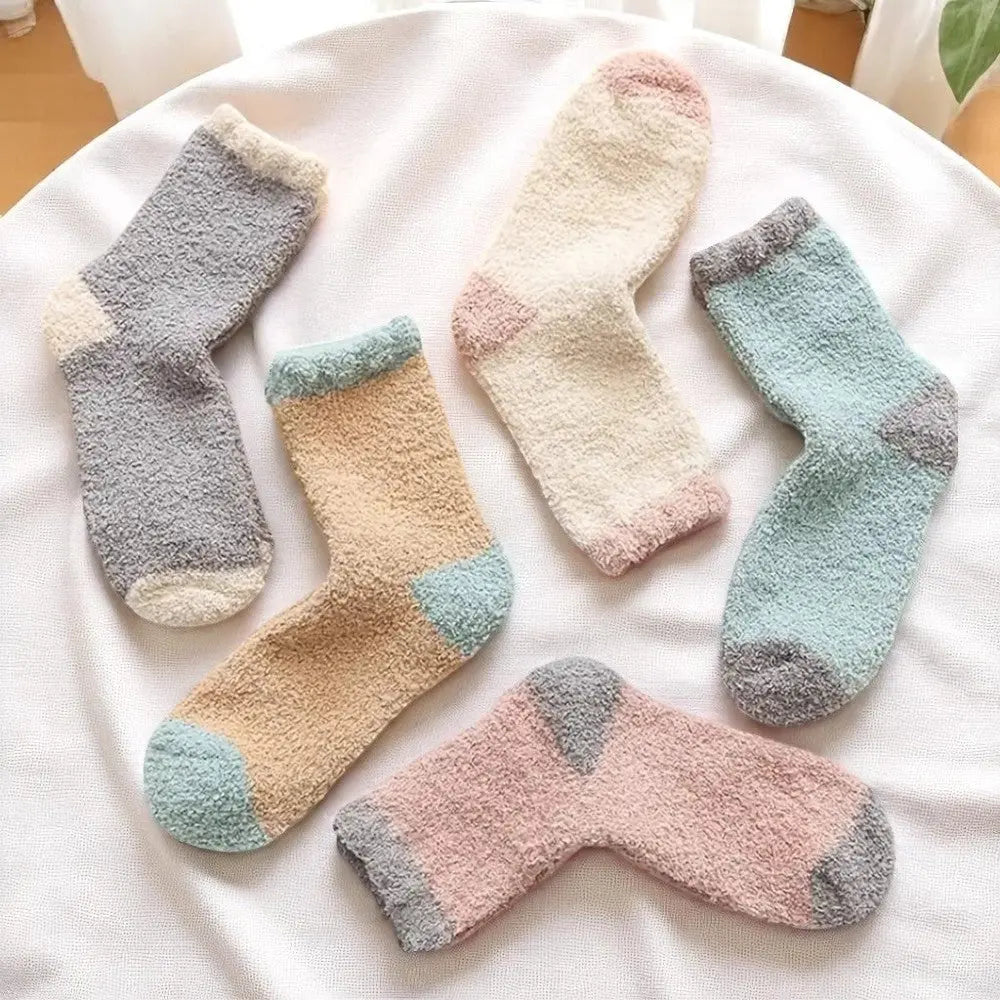 Cinq paires de chaussettes en laine femme colorées étalées en éventail.