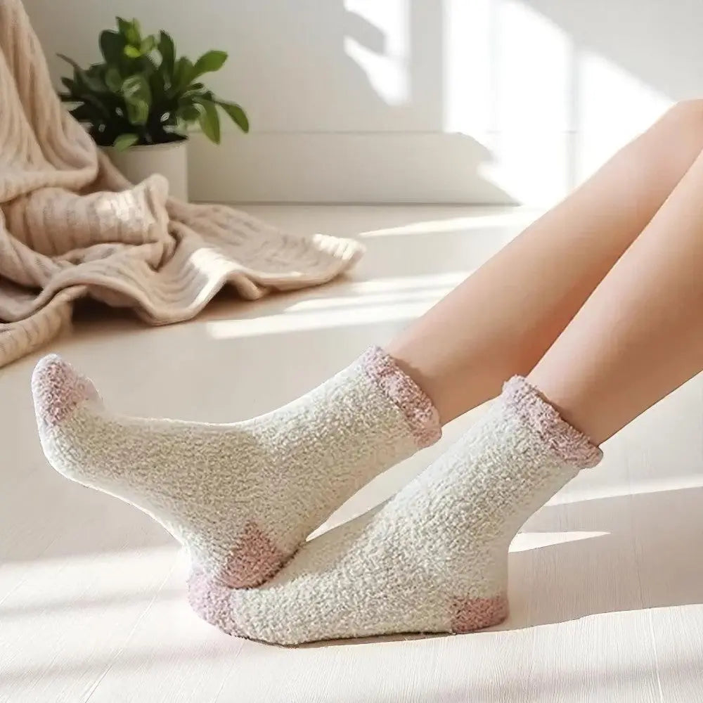 Chaussettes en laine femme blanc cassé et rose portées dans un intérieur cosy.
