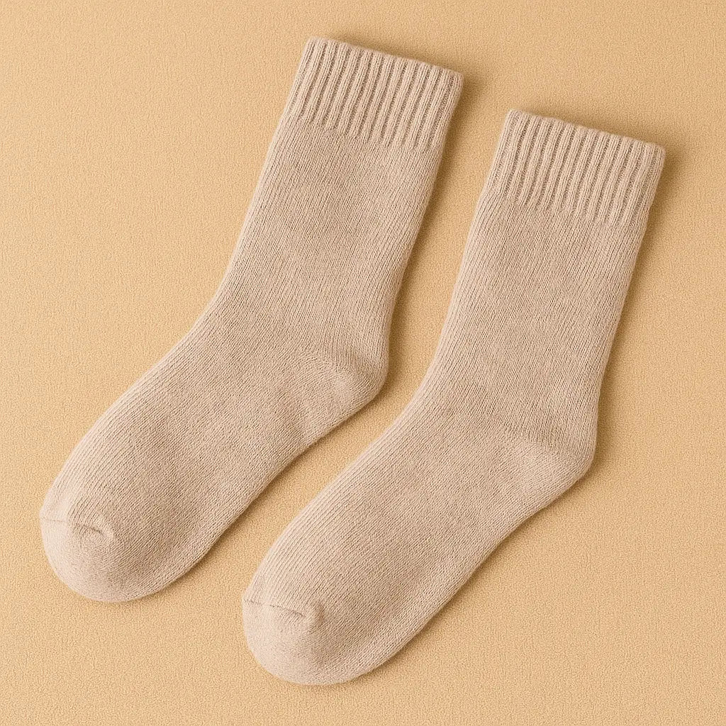 Paire de chaussettes en cachemire beige pour homme sur fond beige.