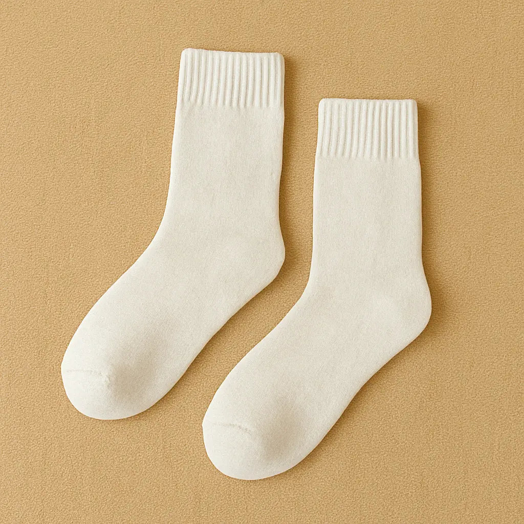 Chaussettes blanches en cachemire pour homme avec fond beige minimaliste.