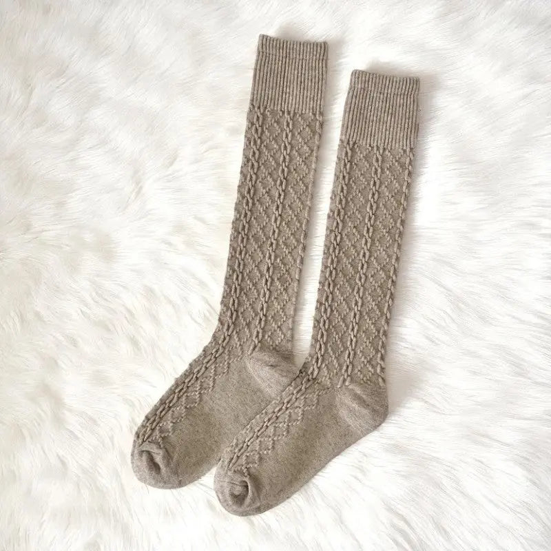 Paire de chaussettes hautes beiges au motif texturé.
