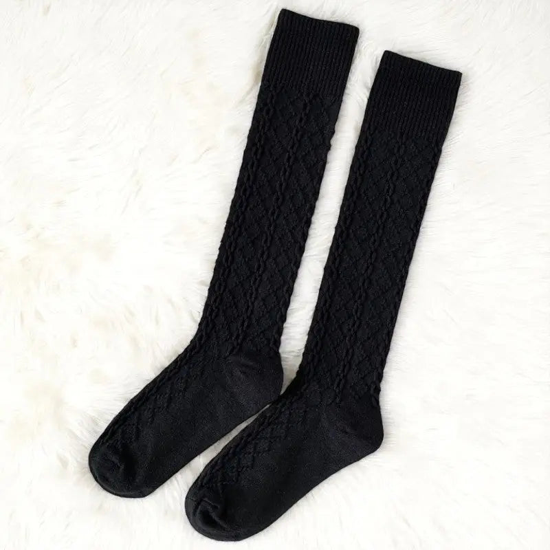 Chaussettes hautes noires élégantes à texture géométrique.