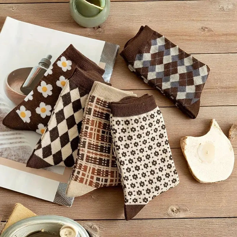 Ensemble de chaussettes hiver rétro pliées, posées sur une table rustique en bois avec des accessoires cosy.