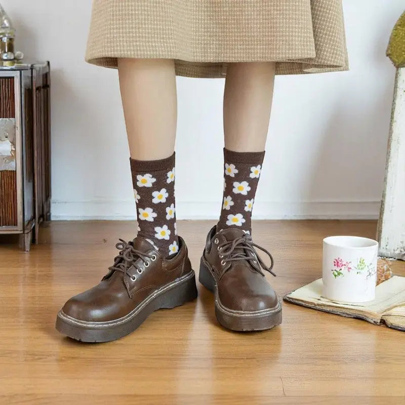Chaussettes rétro à fleurs portées avec des chaussures marron, assorties à une jupe beige pour un look automnal.