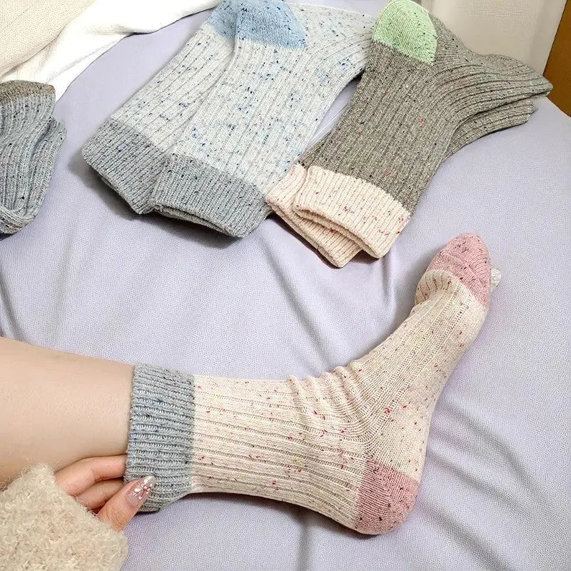 Chaussettes roses mouchetées portées, avec revers gris clair.