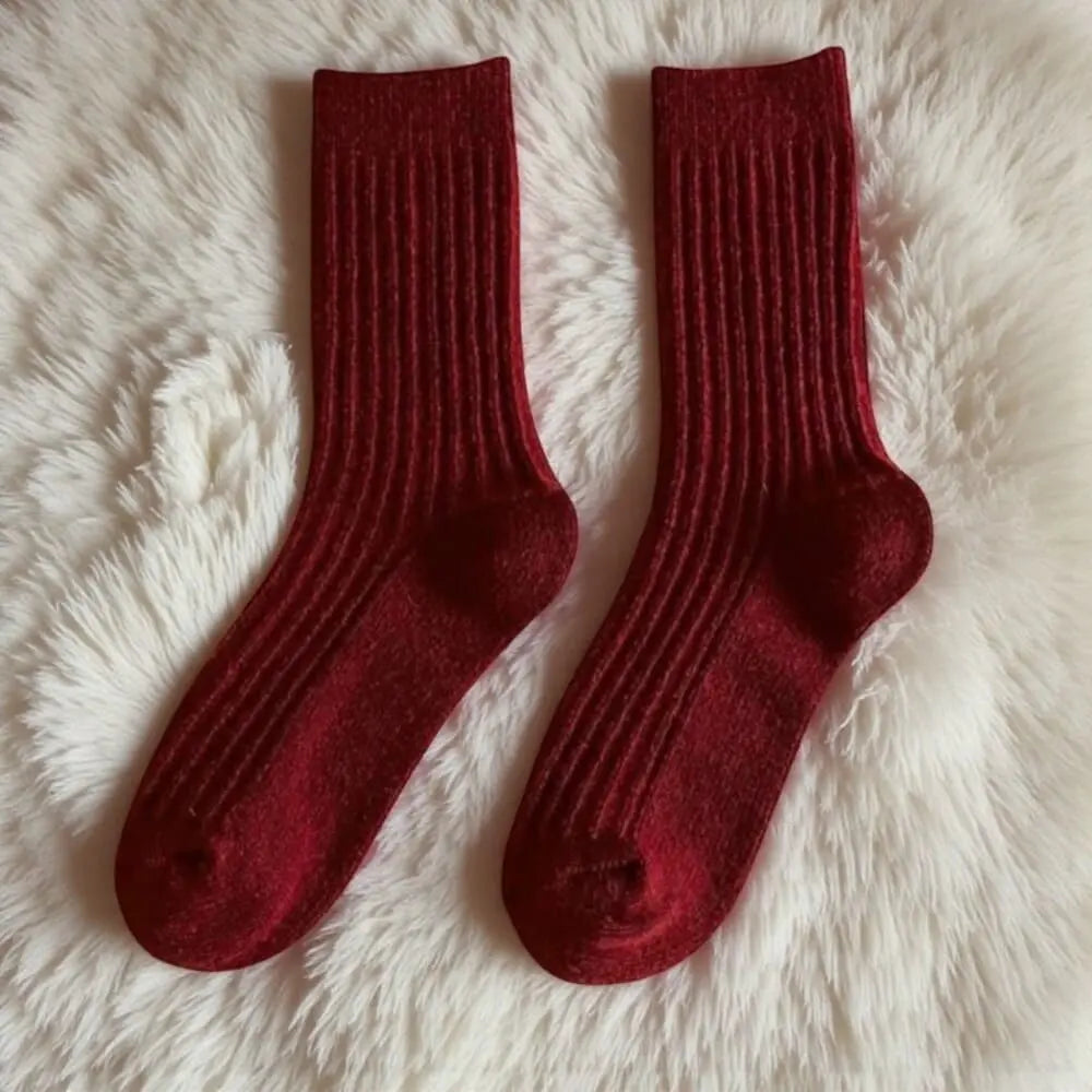 Chaussettes rouges femme modèle pivoine photographiées sur fourrure claire.