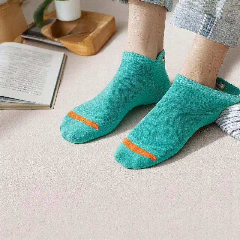 Socquettes vertes portées par un homme sur moquette claire.