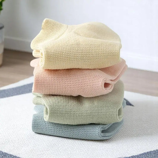 Lot de chaussettes anti transpiration aux couleurs pastel pour femme, empilées avec douceur sur un tapis.