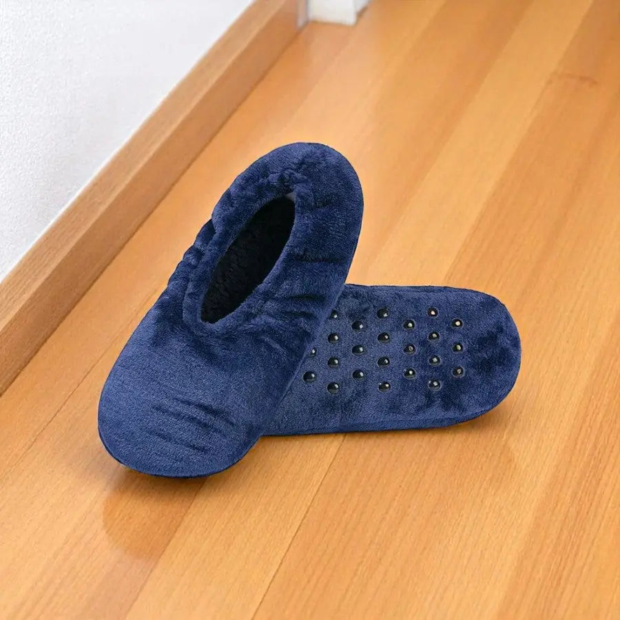 Chaussettes chaussons femme bleu marine avec semelle antidérapante, pose sur parquet clair.