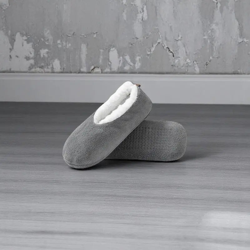 Chaussettes chaussons femme gris foncé avec intérieur blanc et semelle texturée antiglisse.