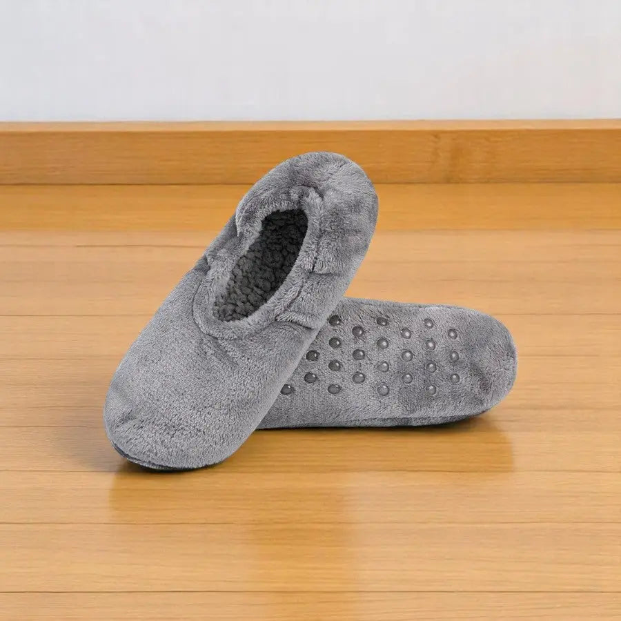 Chaussettes chaussons femme gris clair avec intérieur molletonné et semelle antidérapante.