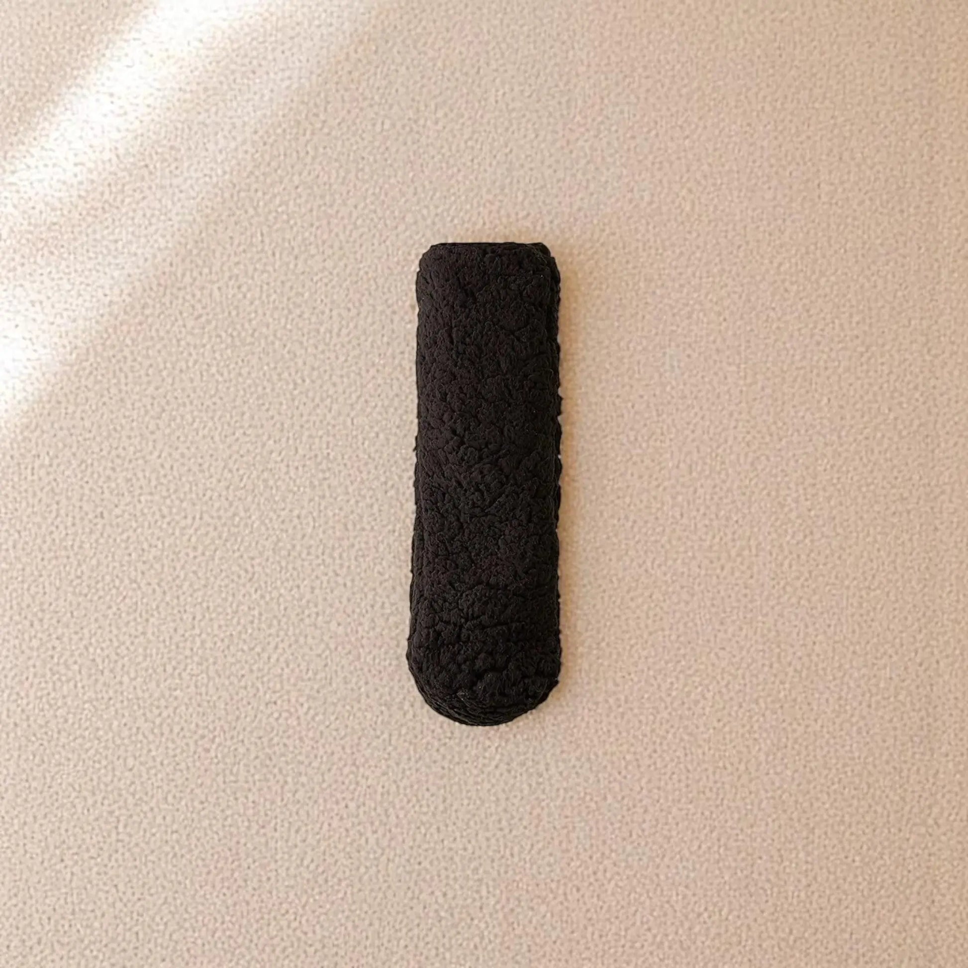 Chaussettes chaussons noirs d’hiver pour homme posés sur tapis beige.