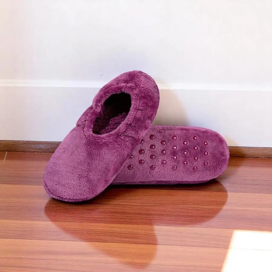 Chaussettes chaussons douillettes violettes pour femme, semelle grip sur parquet rouge.
