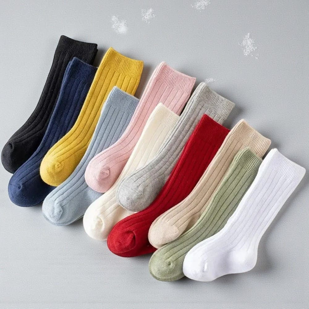 Chaussettes hautes enfant empilées montrant l’épaisseur et la qualité du tissu.