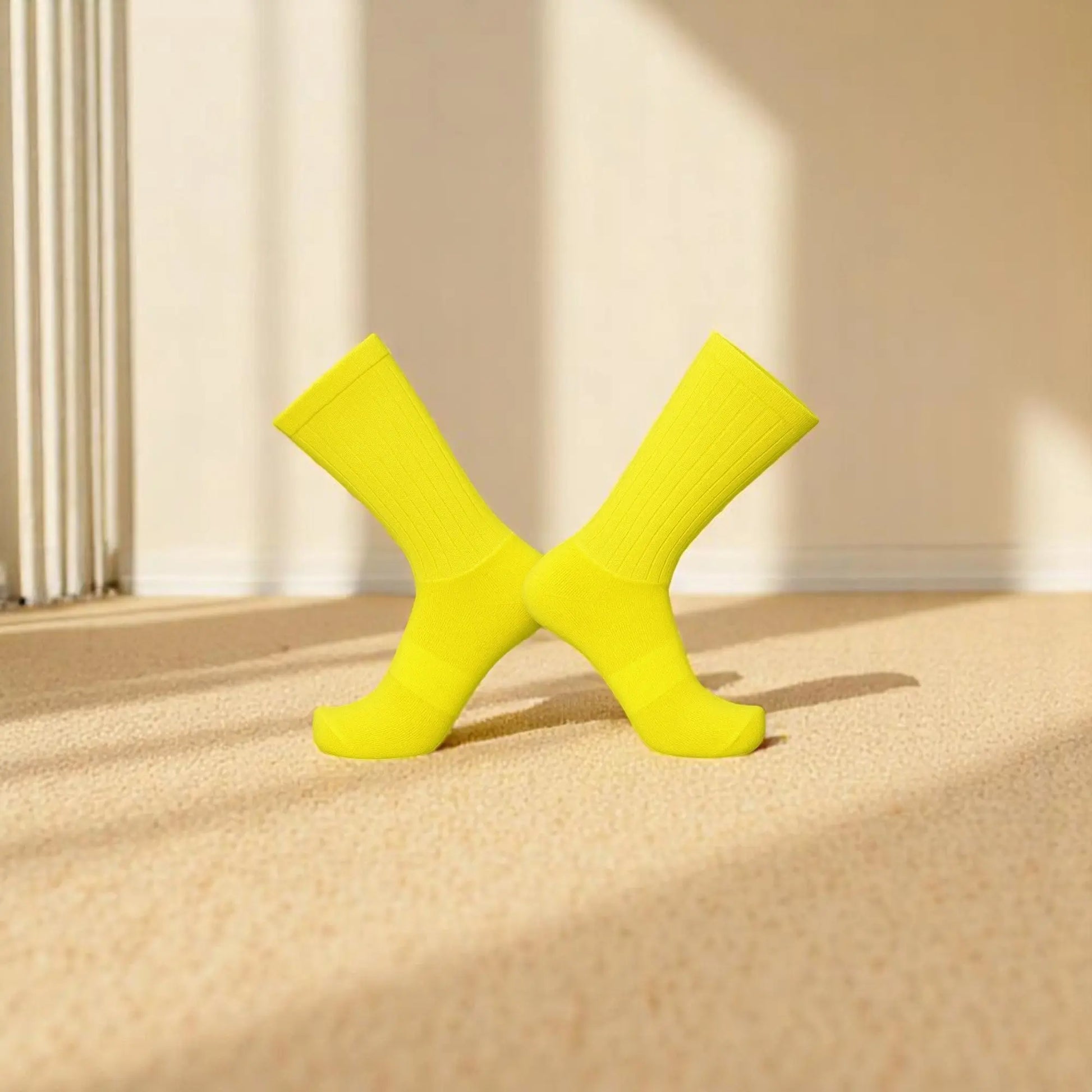 Chaussettes antidérapantes jaunes citron pour homme croisées sur fond beige.