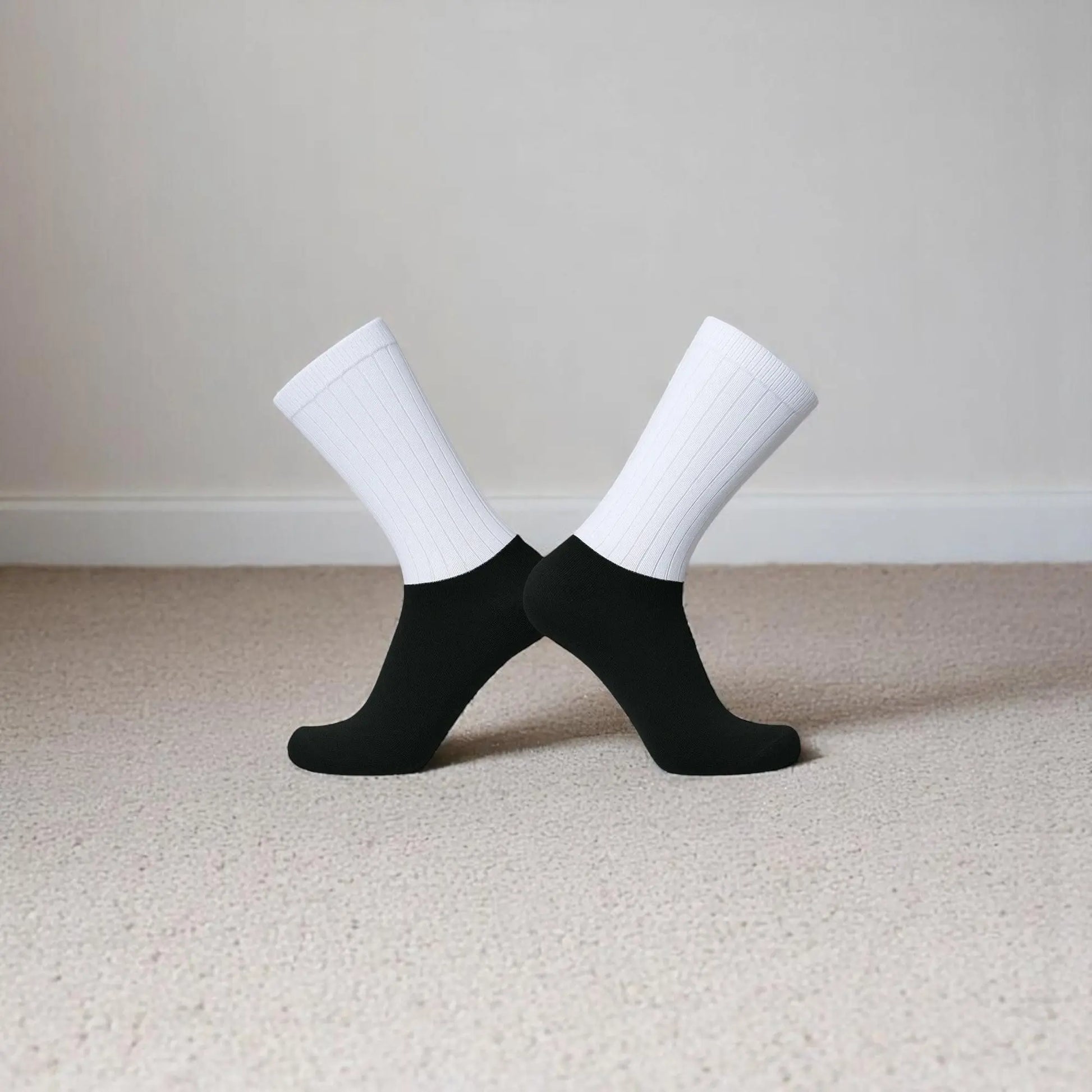 Chaussettes antidérapantes noires et blanches pour homme en position croisée.