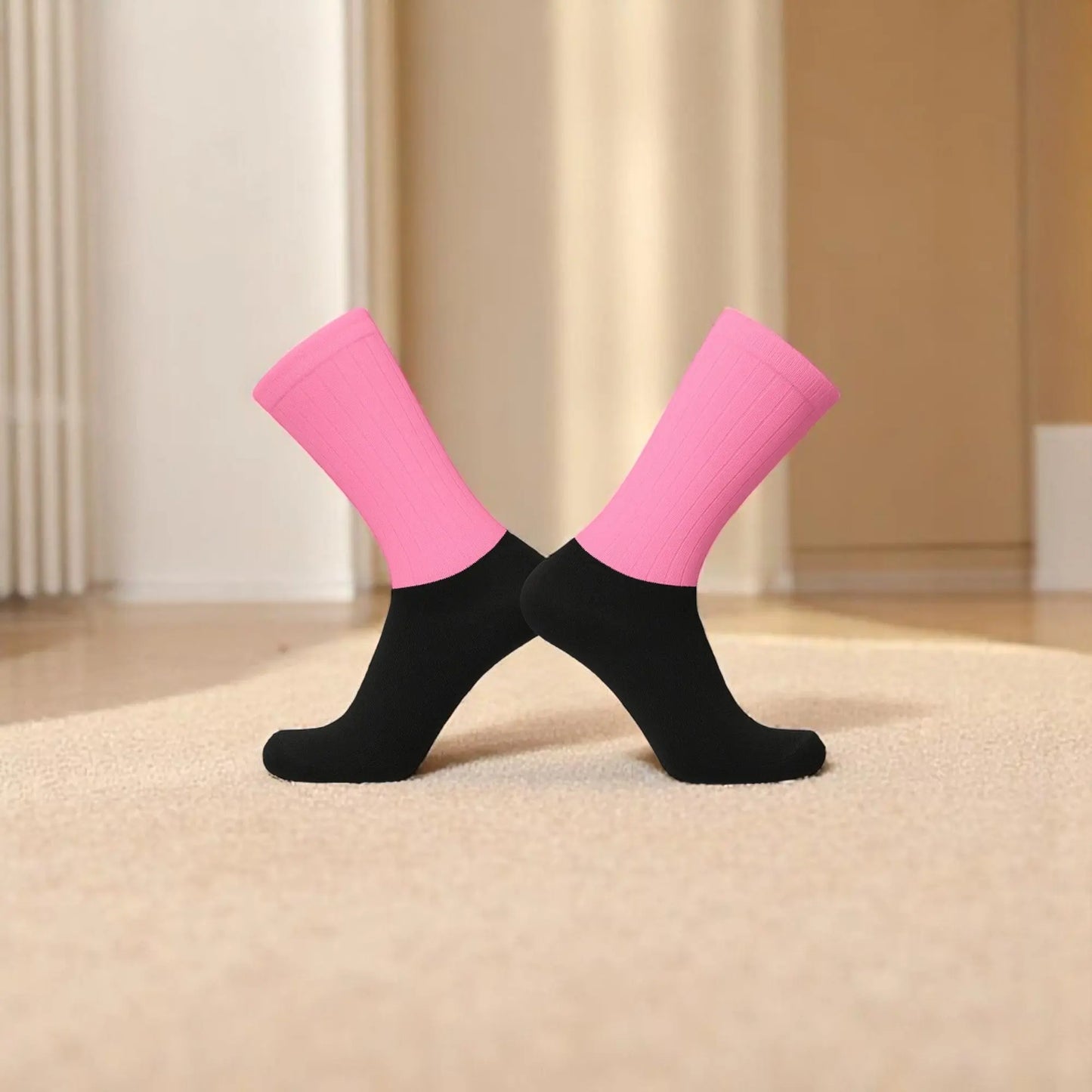 Chaussettes antidérapantes rose et noir pour homme posées sur fond textile.