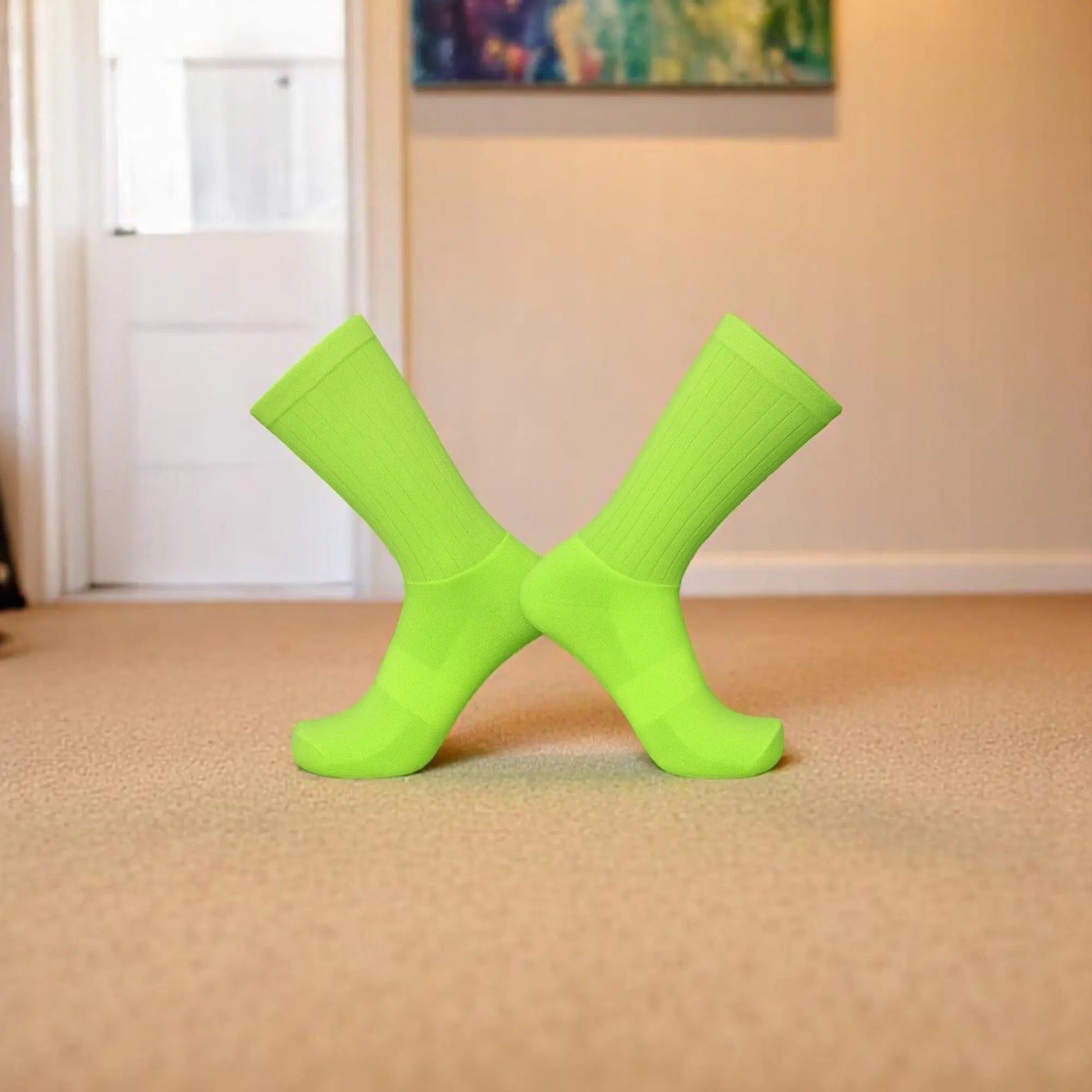 Chaussettes antidérapantes vert pomme pour homme sur un tapis beige.