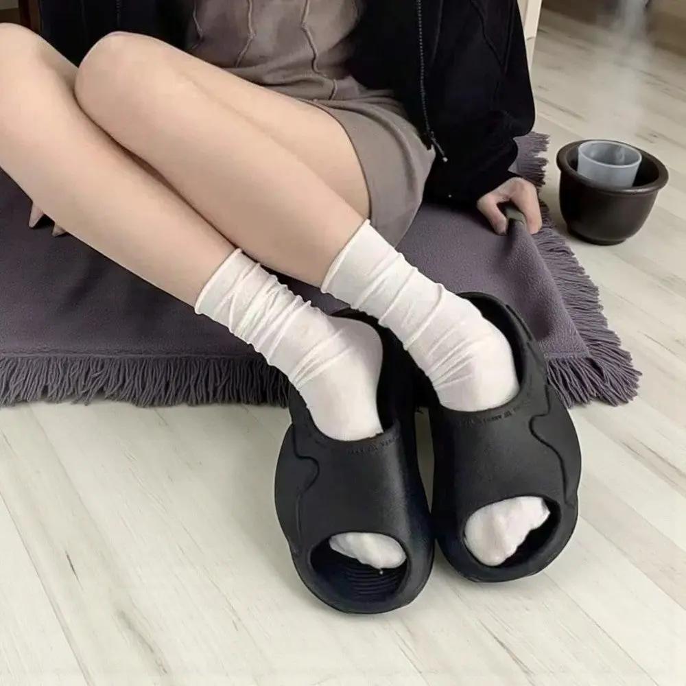 Chaussettes blanches femme portées avec sandales, style détente chic et confort absolu.