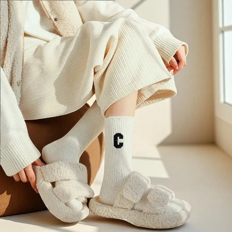 Chaussettes blanches en cachemire pour femme portées avec vêtements d’intérieur.