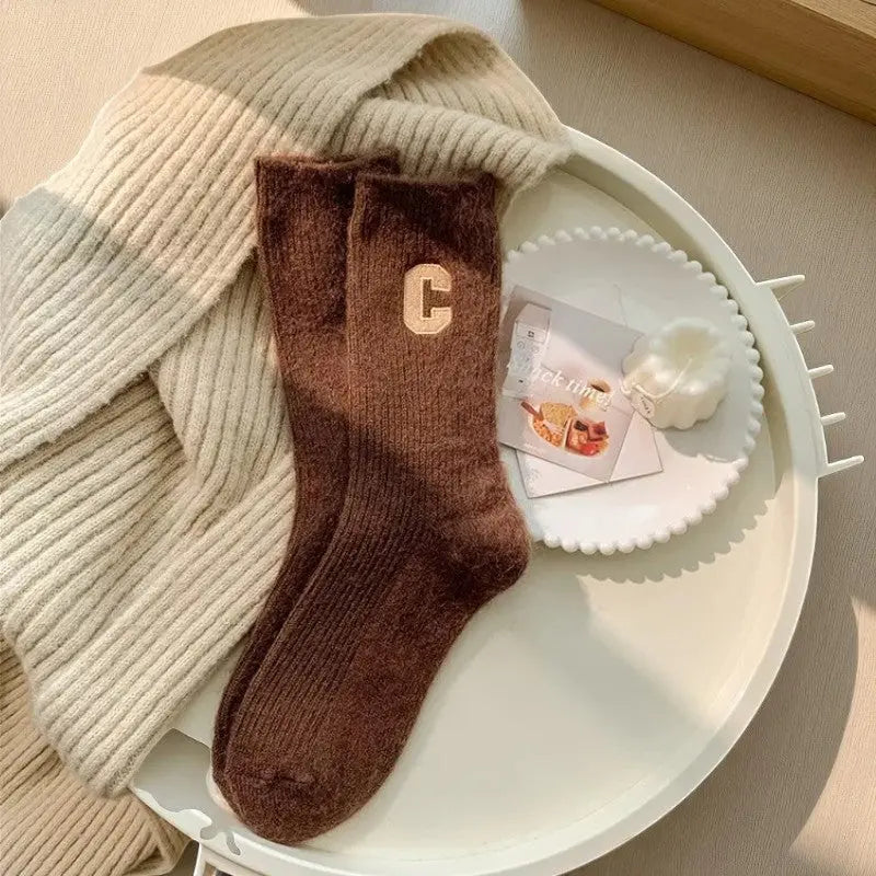 Chaussettes en cachemire couleur marron chocolat pour femme foncé avec motif C beige sur fond doux.