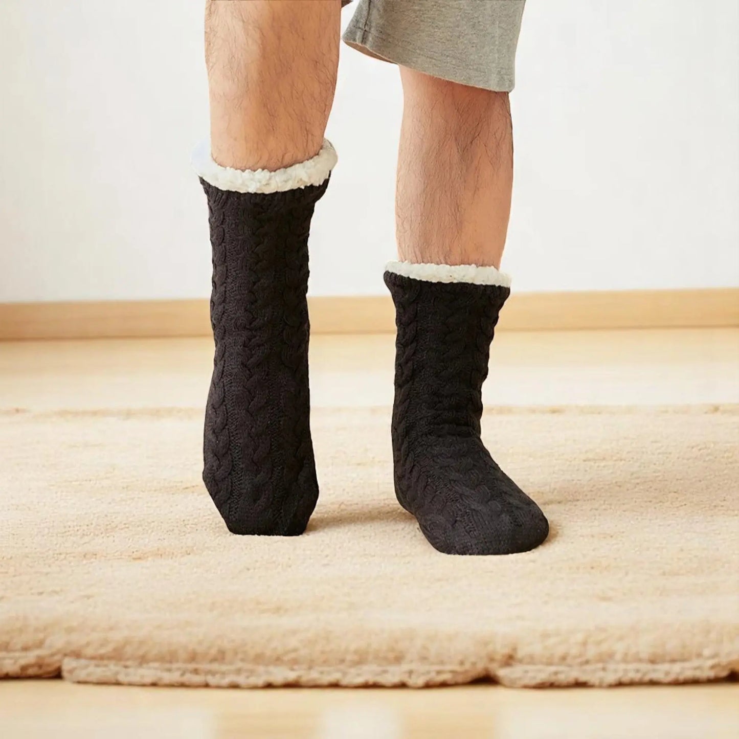 Chaussettes chausson noires pour homme sur tapis beige.