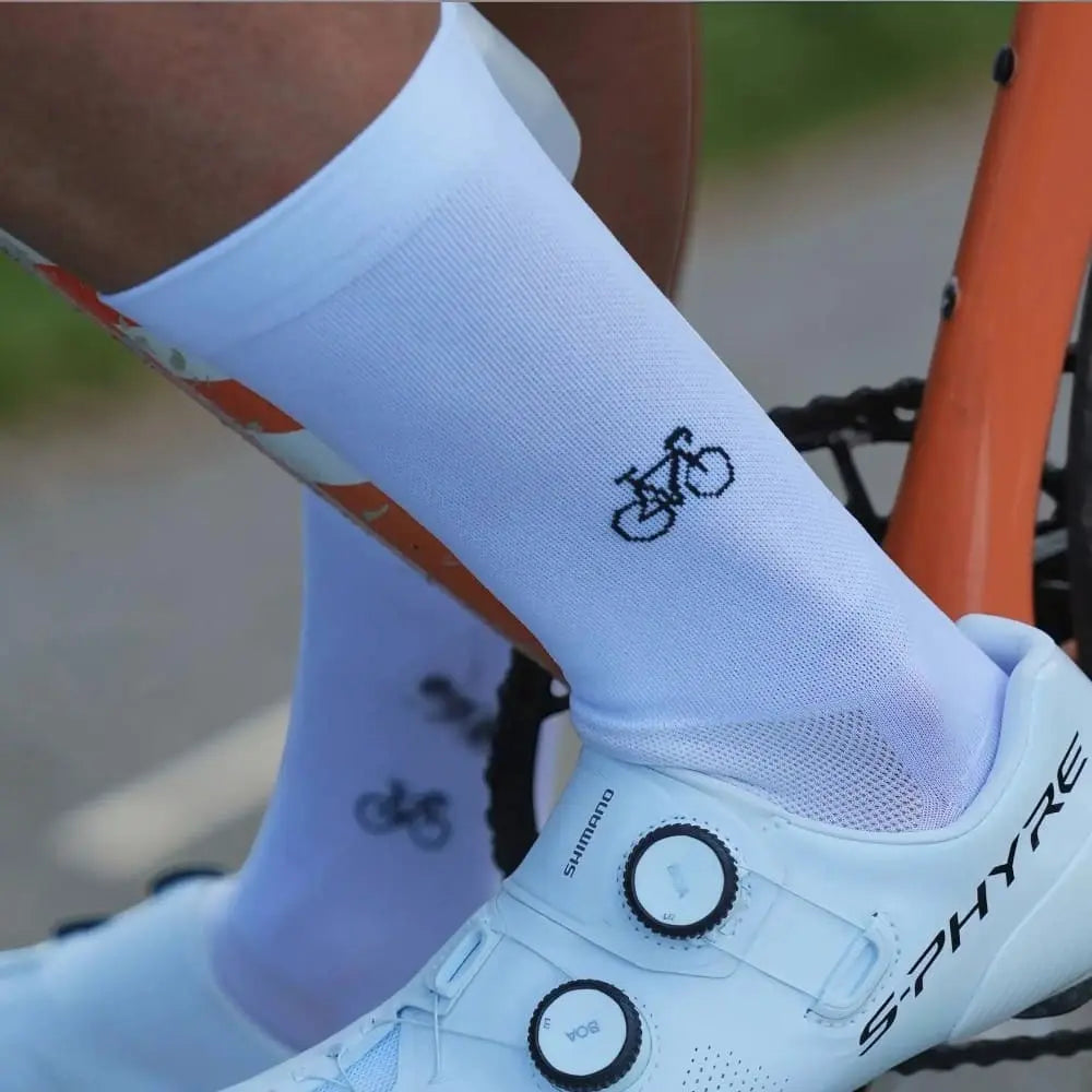 Chaussettes cyclisme blanches pour homme et femme, respirantes et confortables portées avec chaussures vélo.