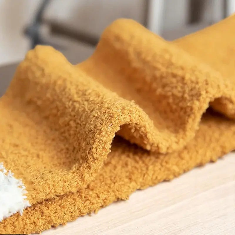 Détail de la matière peluche orange des chaussettes félines douillettes pour femme.