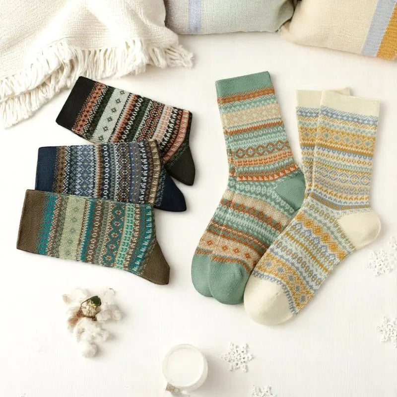 Ensemble de chaussettes chaudes femme en laine avec imprimés hivernaux, étalées à plat dans une ambiance cocooning.