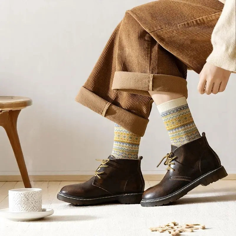 Chaussettes hiver femme aux motifs nordiques crème et ocre, portées avec des bottines pour un look hivernal chaleureux.