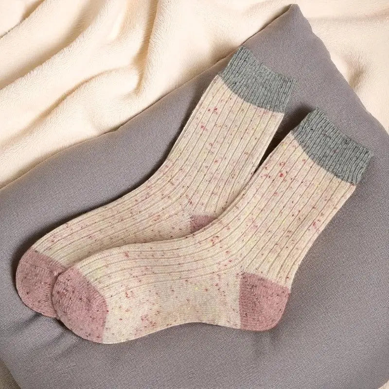 Paire de chaussettes en laine crème mouchetée avec bouts roses et revers gris.