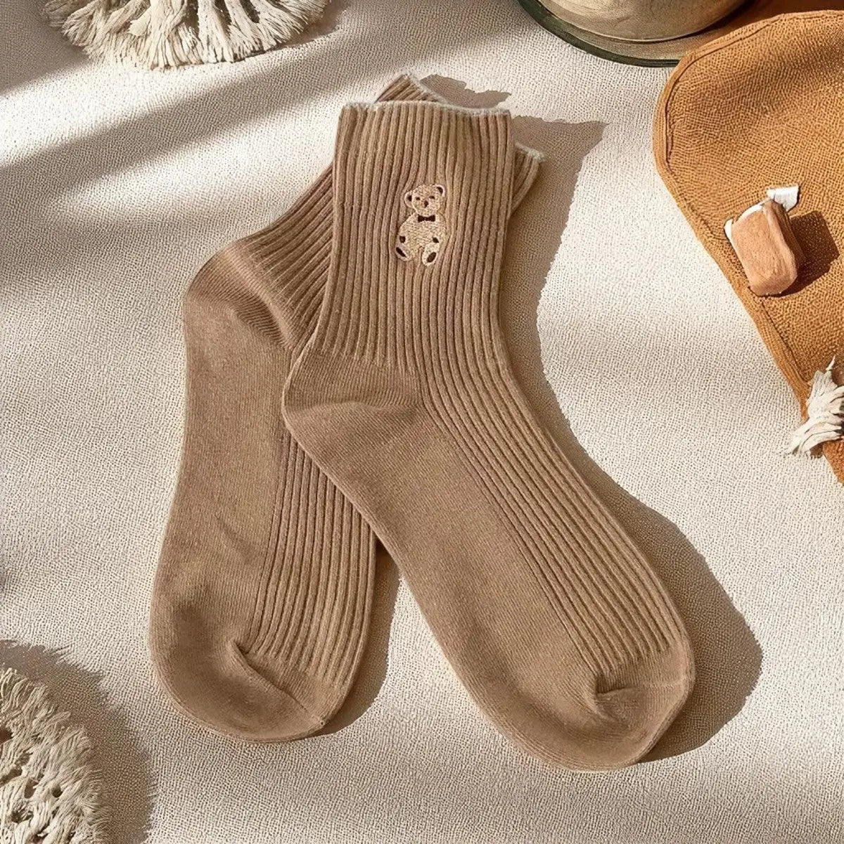 Chaussettes camel à motif ourson, mises en valeur par un éclairage naturel chaleureux.