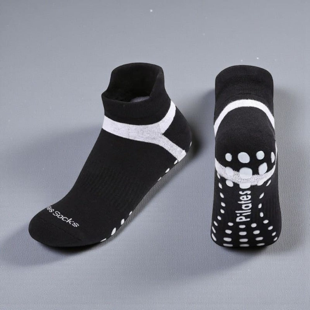 Chaussettes Pilates noir et blanc pour femme avec adhérence renforcée et maintien optimal.