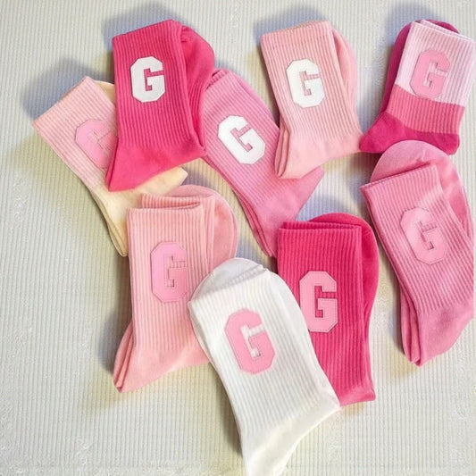 Plusieurs chaussettes rose femme avec logo G blanc et rose.