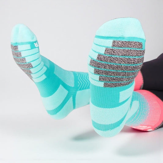 Détail de la semelle de chaussettes running turquoise, zones antidérapantes et absorption des impacts.