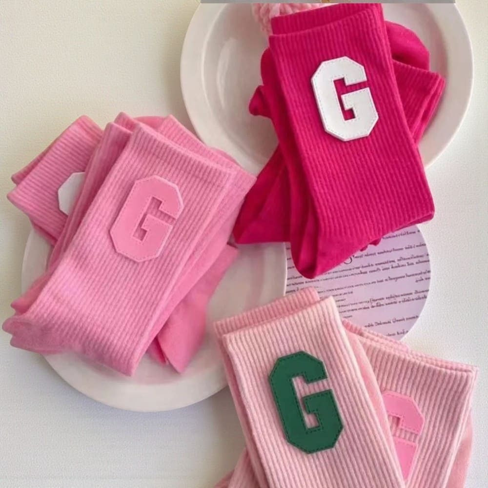 Lot de chaussettes roses femme avec différents logos G colorés.