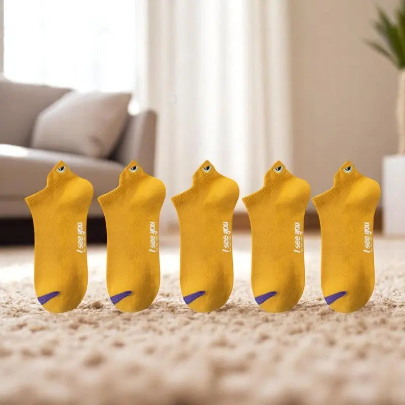 Socquettes jaunes pour homme avec broderie œil sur tapis.