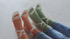 Vidéo de présentation d’un couple portant des chaussettes orange et verte bougeant leurs pieds de façon synchronisée.